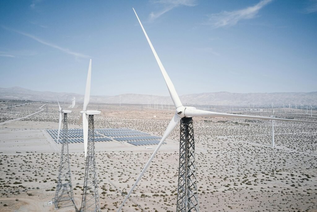Wind turbines and solar panels generating renewable energy in a desert landscape.